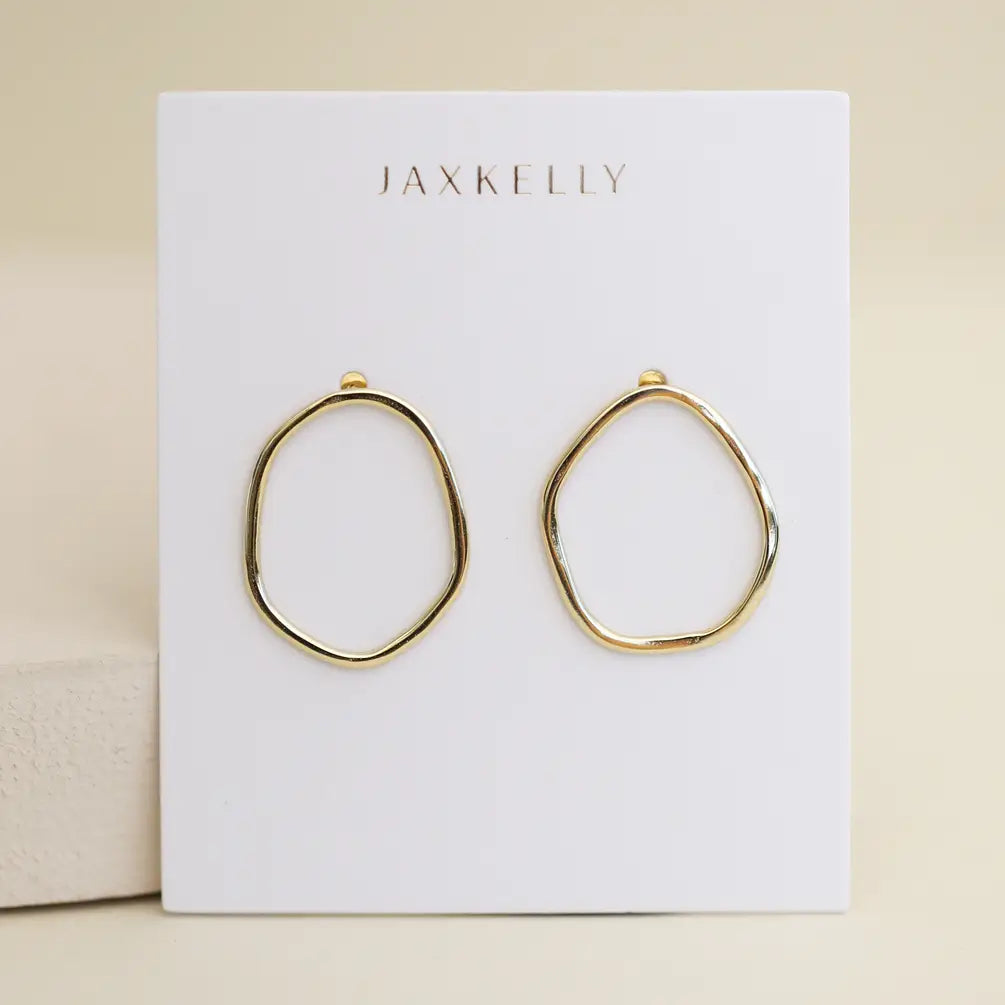 The Gold Organic Hoop by JaxKelly features 18k gold plating and sterling silver posts, shown on a white card with the brand name in gold letters against a soft beige background.
