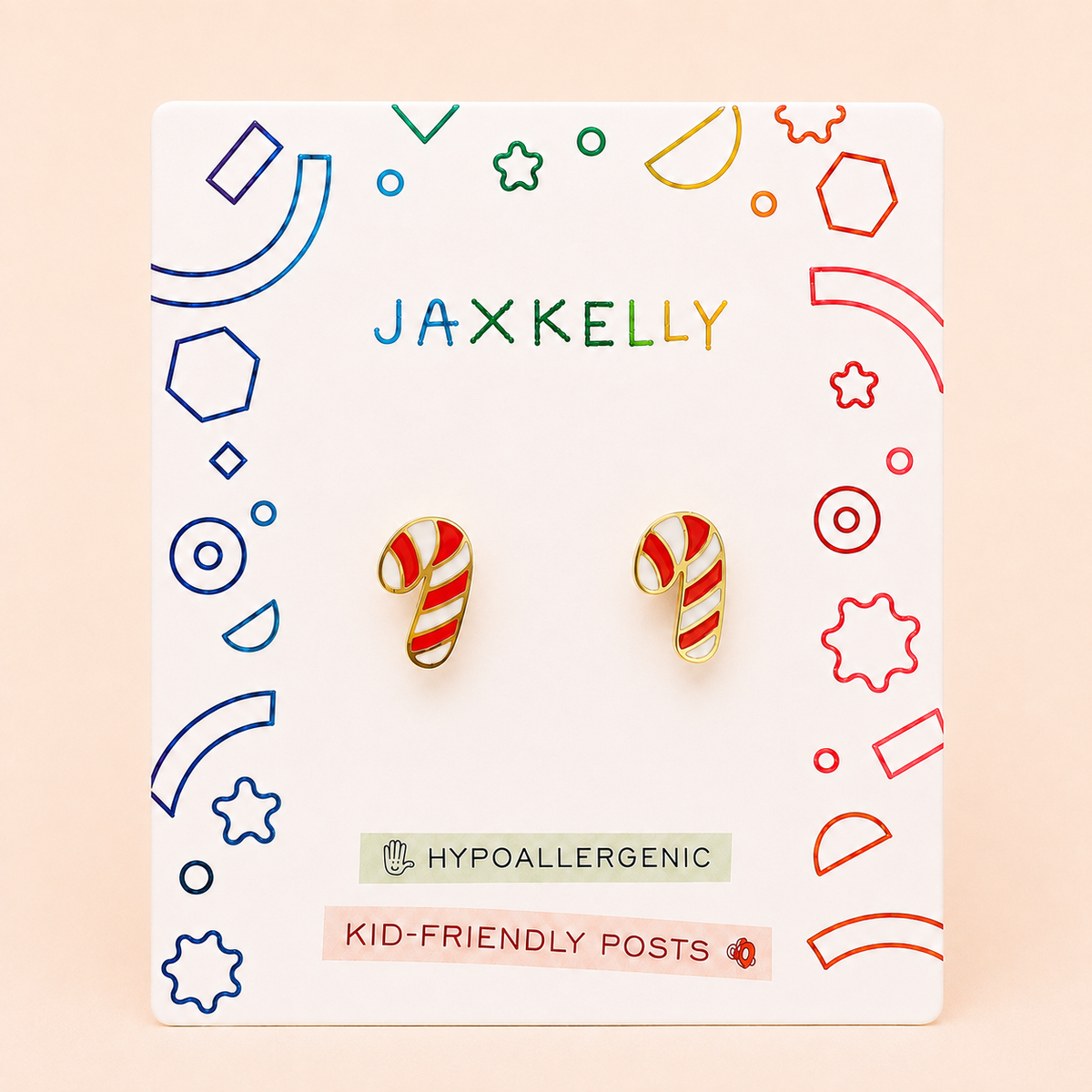 A pair of Candy Cane Enamel Flat Back Kids Earrings from JaxKelly are displayed on a card featuring colorful geometric designs. Labels indicate HYPOALLERGENIC and KID-FRIENDLY POSTS, ensuring these kids earrings are both fun and safe. Crafted from surgical-grade stainless steel, these hypoallergenic earrings are perfect for sensitive ears.