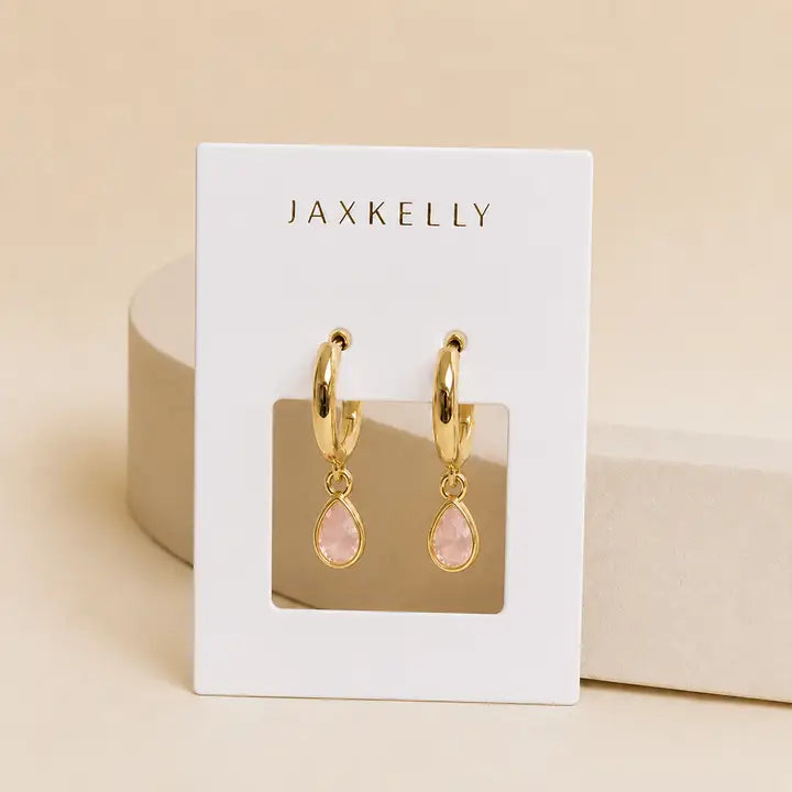 JaxKelly Teardrop Charm Hoop - Rose Quartz earrings featuring teardrop-shaped rose quartz charms on gold hoops, displayed on a white branded card.
