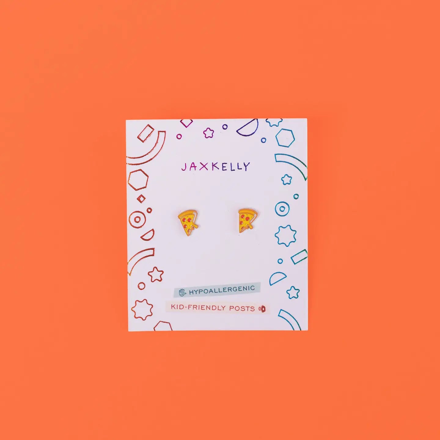 A pair of Pizza Enamel Flat Back Kids Earrings on a JaxKelly card with colorful geometric shapes, against a bright orange background. The card states they are hypoallergenic and kid-friendly—perfect for sensitive ears.