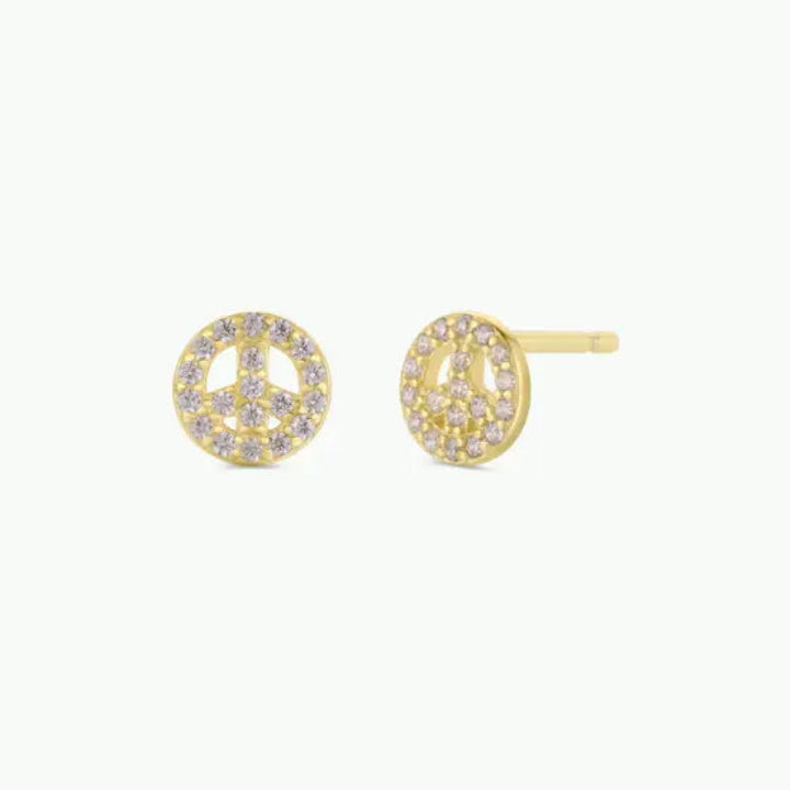 JaxKelly’s Pavé Peace Sign earrings feature 18k gold plating and sparkling CZ stones, shown against a plain light background.