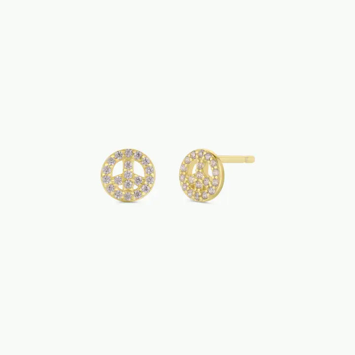 JaxKelly’s Pavé Peace Sign earrings feature 18k gold plating and sparkling CZ stones, shown against a plain light background.