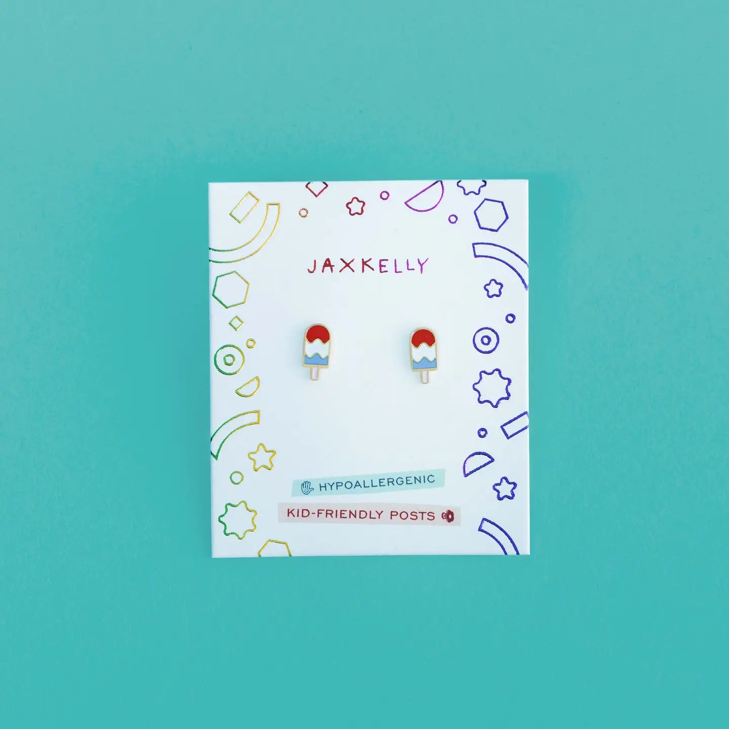 Popsicle Enamel Flat Back Kids Earrings: gold plated, popsicle-shaped with red, white, and blue enamel on a white JaxKelly card featuring geometric designs. Labeled Hypoallergenic Earrings and Kid-Friendly Posts—great for sensitive ears.