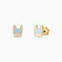 JaxKelly Frenchie Enamel Flat Back Kids Earrings feature two hypoallergenic gold stud earrings shaped like a French bulldog’s face, accented with blue, pink, and white enamel on the ears, face, and nose. These adorable waterproof earrings are perfect for kids with sensitive ears and are showcased on a plain white background.