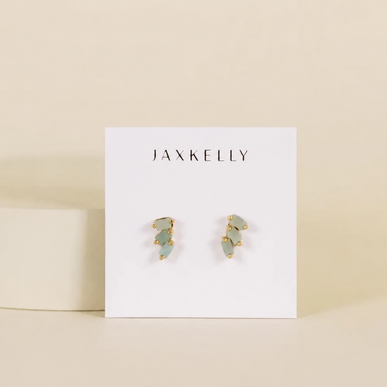 The Offset Trio - Amazonite by JaxKelly features 18K gold plated and pale green amazonite stud earrings, displayed on a white JaxKelly card with a soft beige background.