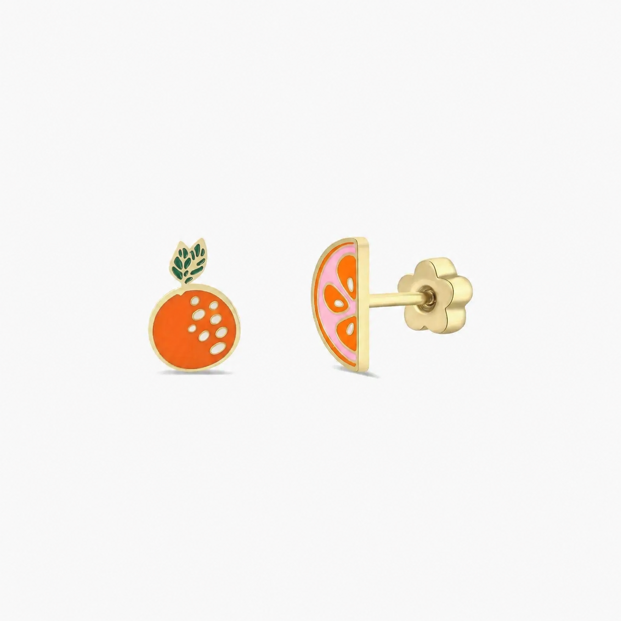 The JaxKelly Orange Enamel Flat Back Kids Earrings feature two hypoallergenic, mismatched studs: one whole orange with green leaves and white dots, and one half orange with pink segments—perfect for sensitive ears.