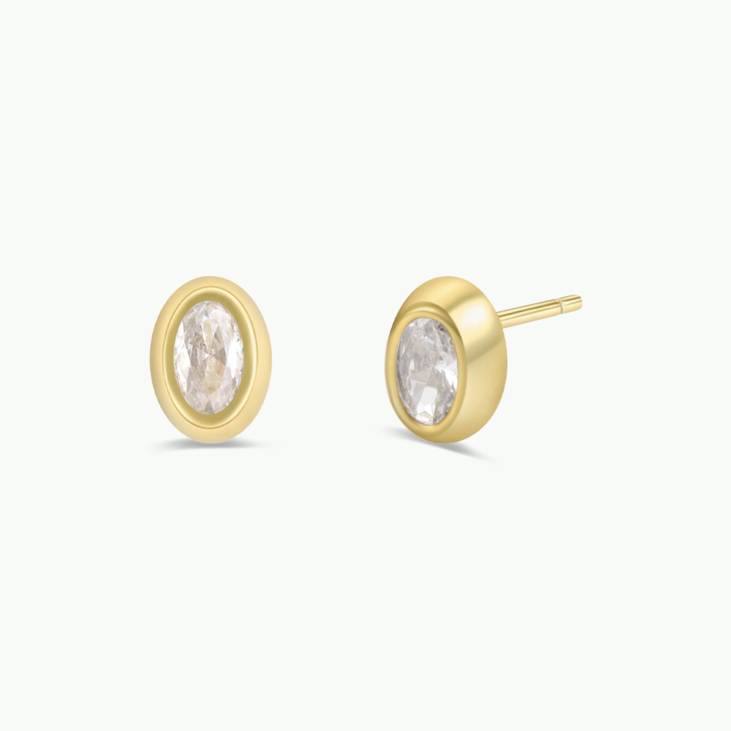 JaxKelly Oval Bezel - White CZ stud earrings featuring oval white gemstones in gold bezels.