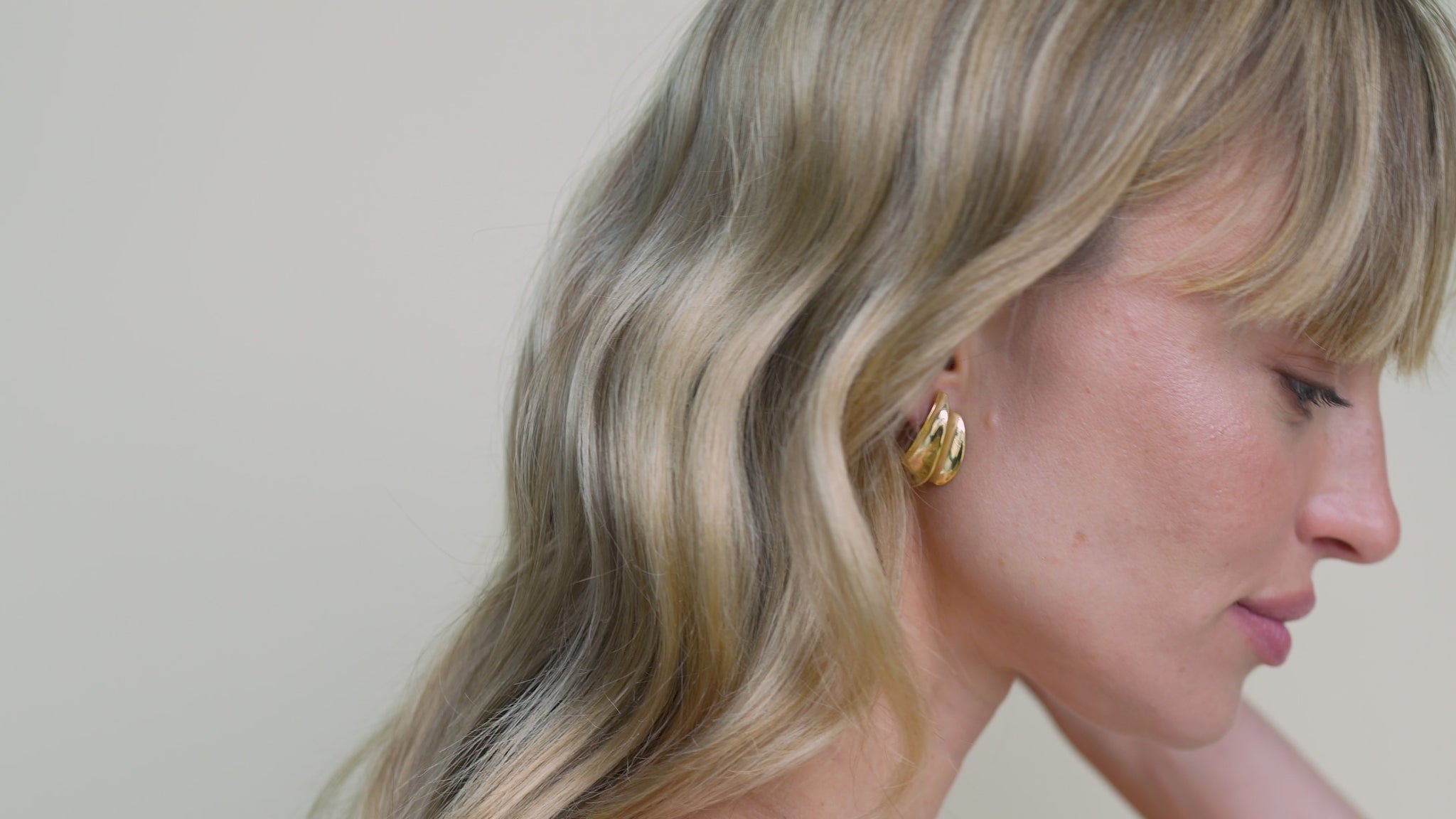 JaxKelly's Gold Bold Wave earrings on a model.