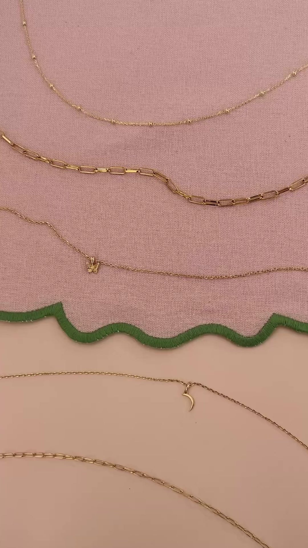 JaxKelly's Small Link Necklace and other JaxKelly necklace styles on a pink fabric backdrop with green trim.