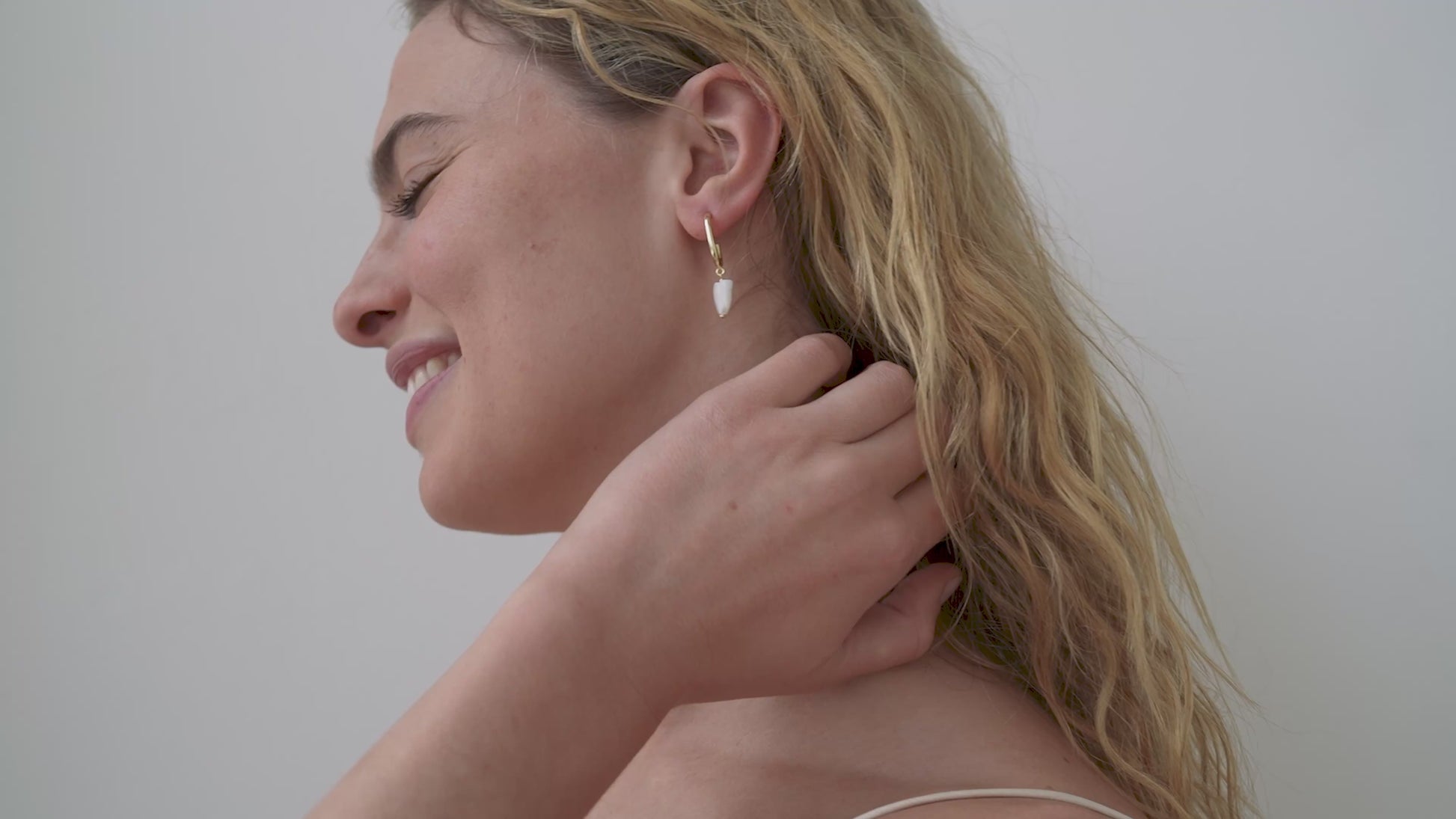JaxKelly's Heart Drop earrings with Mother of Pearl on a model.