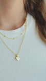 JaxKelly's Gold Ball Necklace and other JaxKelly jewelry styles on a model.