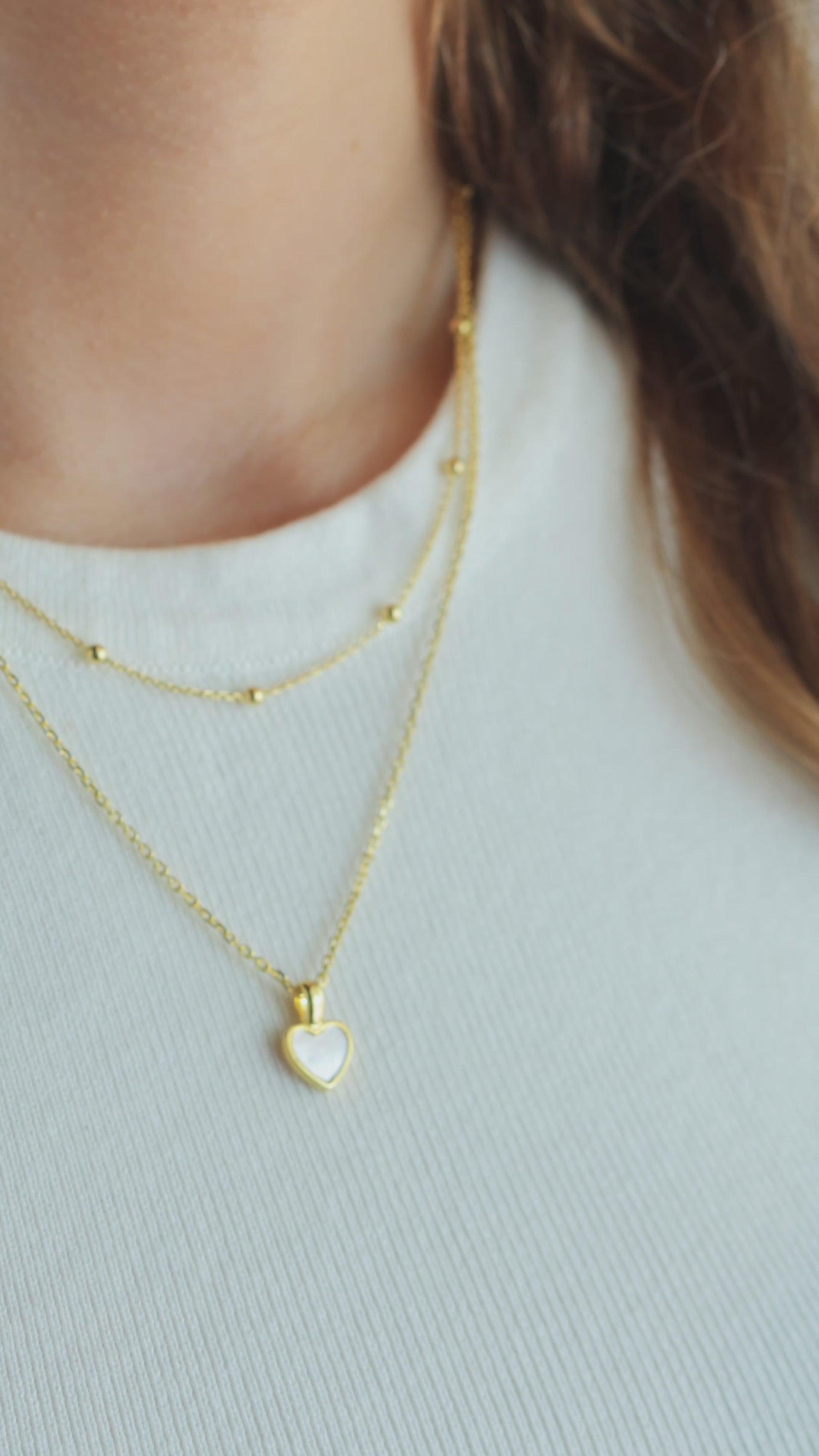 JaxKelly's Gold Ball Necklace and other JaxKelly jewelry styles on a model.