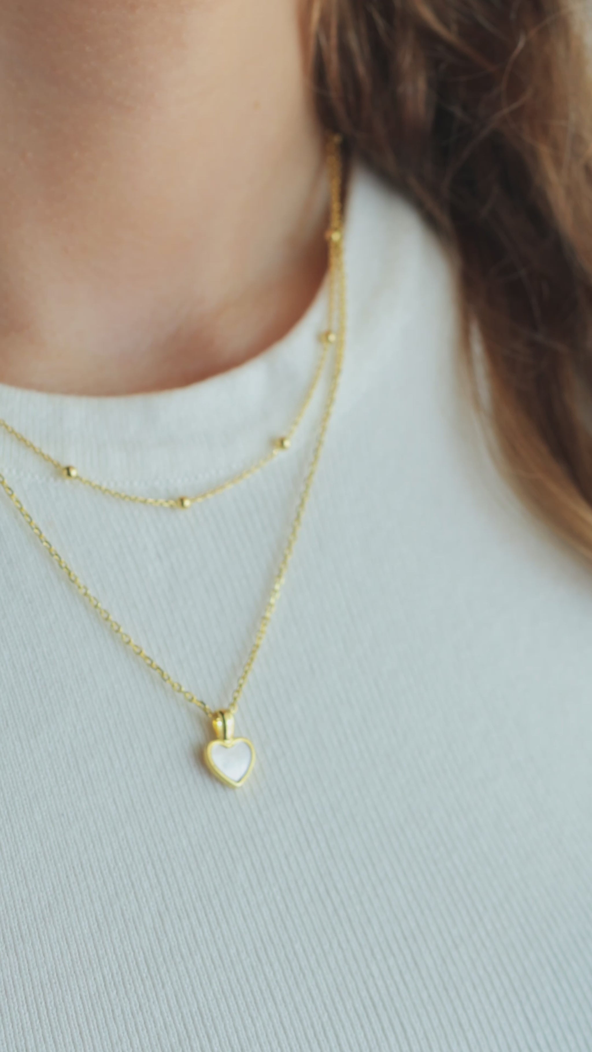 JaxKelly's Gold Ball Necklace and other JaxKelly jewelry styles on a model.