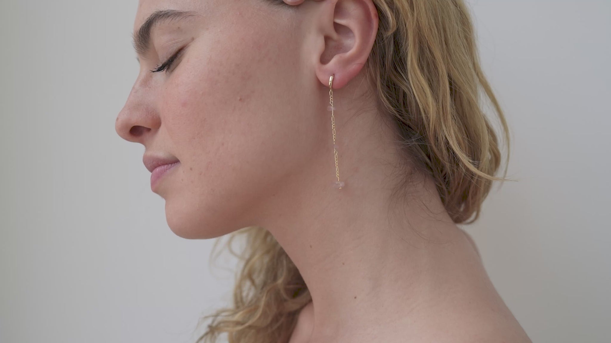 JaxKelly's Raw Gemstone Chain Drop earrings in Rose Quartz on a model.