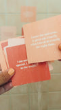 JaxKelly's Positivity Shower Affirmations under running water, being placed on a tan-colored tile shower wall.