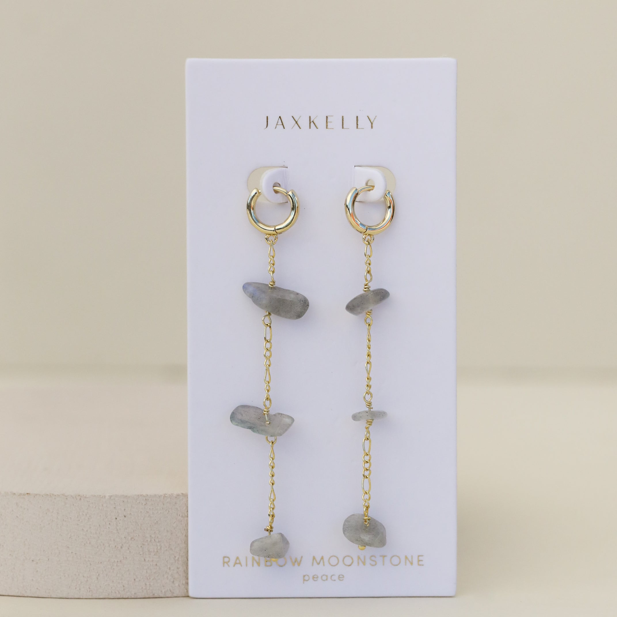 Raw Gemstone Chain Drop Earring - Rainbow Moonstone: Gold chain drop earrings with dangling chains and irregular rainbow moonstone beads, displayed on a white JaxKelly card marked "RAINBOW MOONSTONE peace." Tarnish free for effortless style.