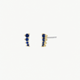 The Mini Crawler - Sapphire CZ - Gold Earrings by JaxKelly are small, gold-plated studs set with five dark blue sapphire CZ stones in a vertical line, offering hypoallergenic and elegant sparkle for any look.
