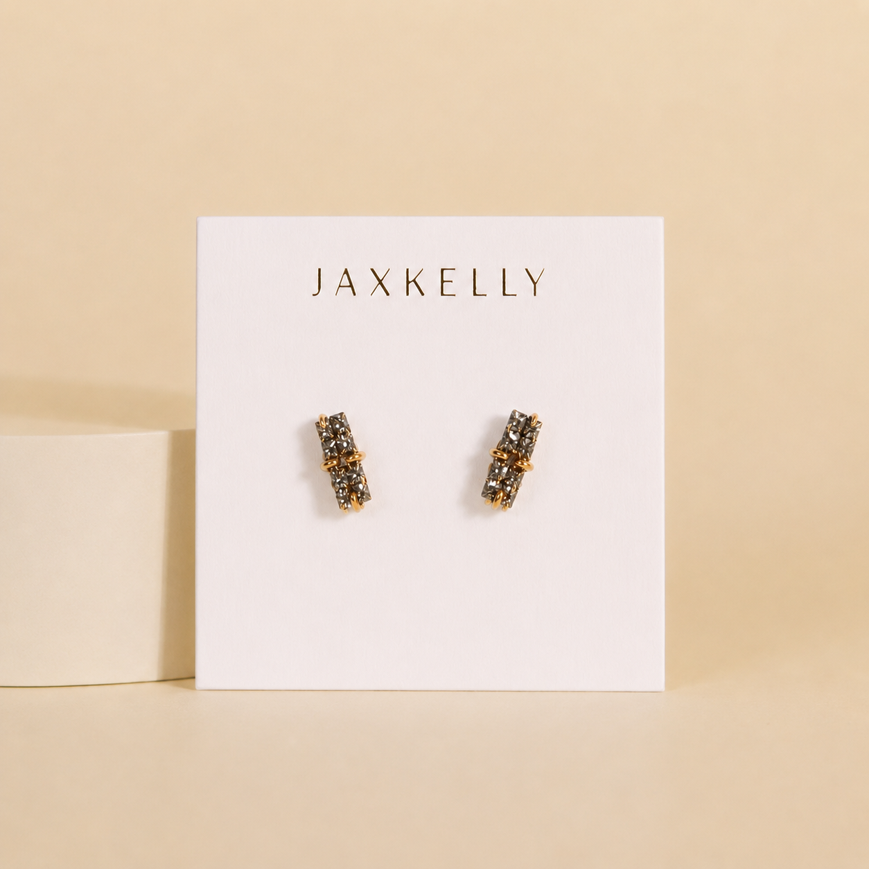 A pair of Silver Bar Druzy earrings by JaxKelly is displayed on a white card with "JaxKelly" at the top, set against a beige background.