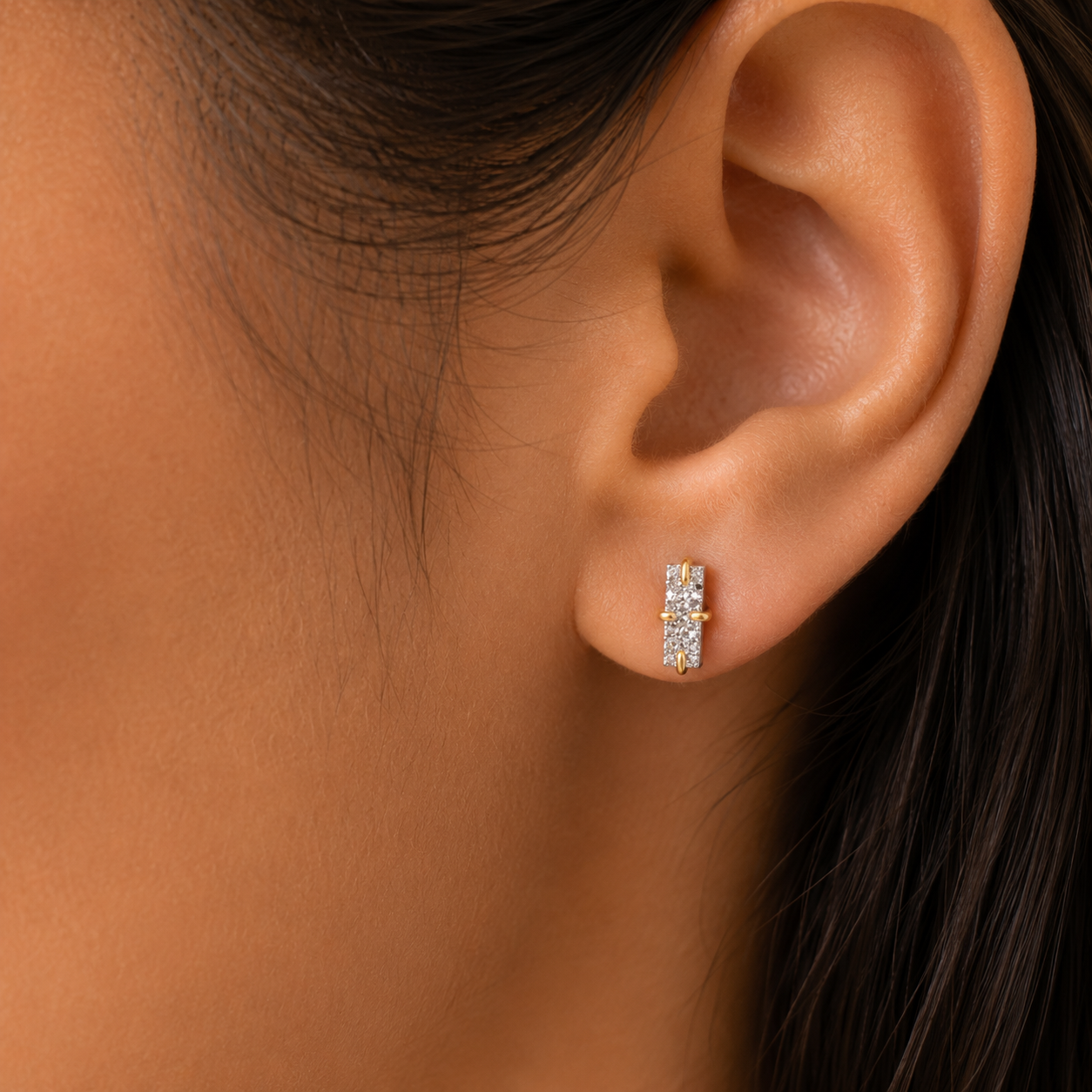 Close-up of a woman’s ear wearing the JaxKelly Silver Bar Druzy earring, a small and elegant hypoallergenic piece featuring sparkling gemstones. Her dark hair is tucked behind her ear, shown against a neutral background.