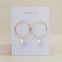 The Simple Hoop with Pearl features minimalist gold hoops with white pearls, presented on a white JaxKelly card against a neutral backdrop.