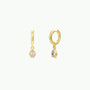 A pair of Teardrop Charm Hoop - White CZ earrings, each featuring a dangling, teardrop-shaped stone.
