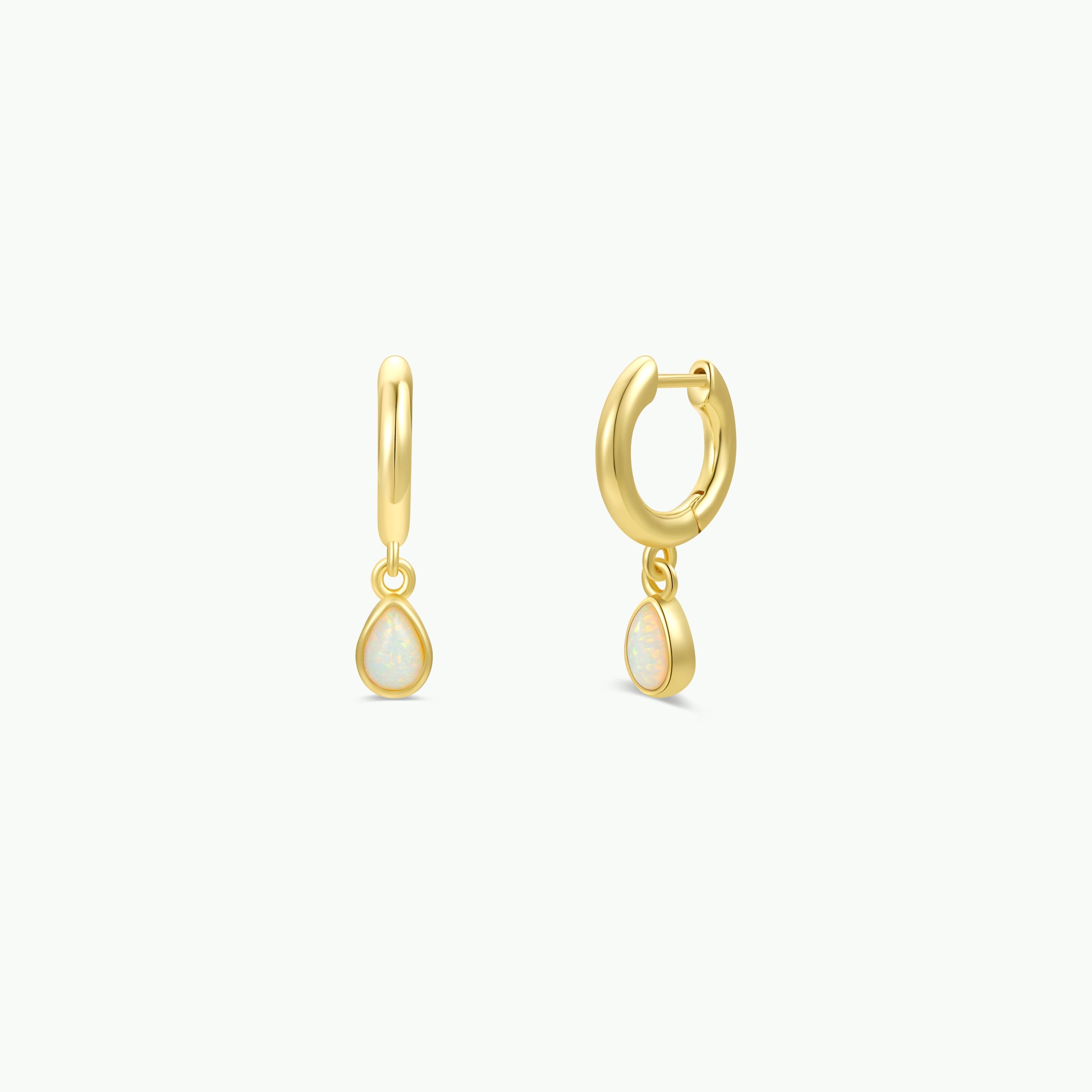 A pair of JaxKelly Teardrop Charm Hoop - White Opal earrings.
