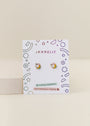 Unicorn Enamel Flat Back Kids Earrings with rainbow accents on a JaxKelly card with colorful geometric designs, labeled “hypoallergenic” and “kid-friendly posts.”.