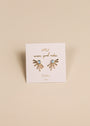 A pair of Sun Ray - Fire Opal stud earrings with lab-grown Fire Opal and 18k gold plating, shaped like sunbursts, displayed on a white JAXKELLY card reading "wear good vibes, OPAL, joy" against a beige background.