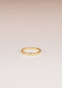The Celestial Ring, a simple gold stacking ring with small star-shaped engravings, is displayed on a plain, light-colored background.
