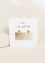 The Stud Chain Huggie features eye-shaped white CZ studs with dangling chains, crafted in 18k gold-plated sterling silver, and displayed on a white JaxKelly card reading "wear good vibes" in gold script.