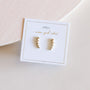 Champagne Crawler earrings—small, gold, star-shaped with 18k gold plating and sterling silver posts—are displayed on a JAXKELLY card reading “wear good vibes” in gold, set against a light neutral background.