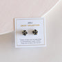 A pair of Black Druzy Prong stud earrings with 18k gold plating is displayed on a white JaxKelly Druzy Collection card, noting these handpicked druzy stone studs are sisters, not twins.