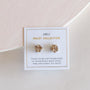 A pair of Rose Gold Druzy Prong stud earrings with irregular shapes, crafted from natural druzy stone, is displayed on a white card labeled "Druzy Collection" with the note "sisters not twins" against a light pink background.
