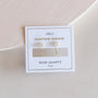 The Rose Quartz Huggie is a gold earring featuring rose quartz gemstones, displayed on a white card with gold trim labeled "Gemstone Huggies" and "Rose Quartz Love"—ideal for fans of dainty earrings.