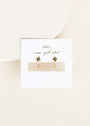 Star Huggie: 18k gold plated hoop earrings with small star charms and clear stones, shown on a white JaxKelly card that reads "wear good vibes" in cursive, against a light beige background.