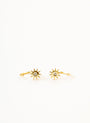 A pair of Sun Huggie earrings, gold in color and sun-shaped with a central clear stone, shown on a plain white background.