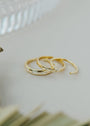 The Celestial Ring, an elegant gold band with delicate diamond accents, is showcased on a light surface, creating a minimalist and sophisticated look.