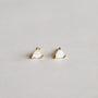 A pair of Mother of Pearl Mini Energy Gems - Calming: small, triangular earrings with white centers and 18k gold plated edges, displayed on a plain, light background.