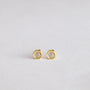 The Minimalist Hexagon earrings are a pair of small, gold plated hexagons shown on a plain, light background.