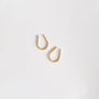 A pair of Minimalist Horseshoe earrings, crafted with 18k gold plating and a teardrop-shaped hoop design, are displayed on a plain white background.