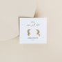 Amazonite Moon Drop earrings feature gold plated sterling silver crescent moons with small green amazonite stones, displayed on a white “JAX KELLY, wear good vibes, AMAZONITE, hope” card against a light beige background.