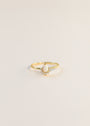 The Opal Burst Ring features a delicate 18k gold-plated band with a teardrop-shaped lab-grown Opal center and small round accent stones, shown on a plain light background.
