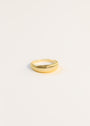 The Ridged Ring, featuring a ridged textured design and 18k gold plating, is displayed against a simple, light background.