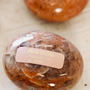 The Moonstone Palm Stone - Luck rests on a light surface, perfect for your manifestation practice, with another genuine crystal stone partially visible in the background.