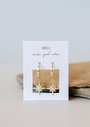 The Starburst Mini Hoop earrings feature gold hoops with starburst charms and small gemstones, displayed on a white card reading "JAXKELLY wear good vibes," against a neutral background.