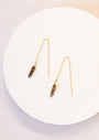 The JaxKelly Gemstone Threader - Smoky Quartz features delicate 18k gold plated earrings with dark Smoky Quartz pendants, shown on a round white surface.